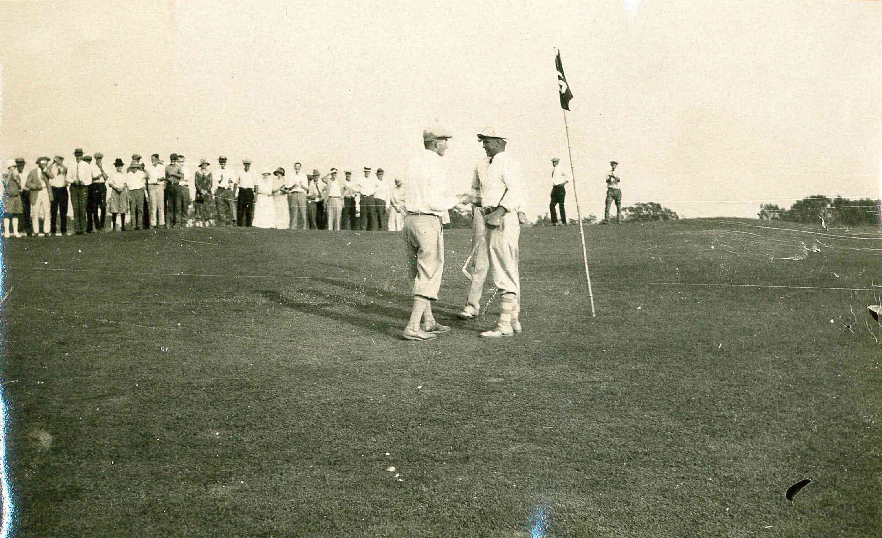 a group of men standing on a golf course