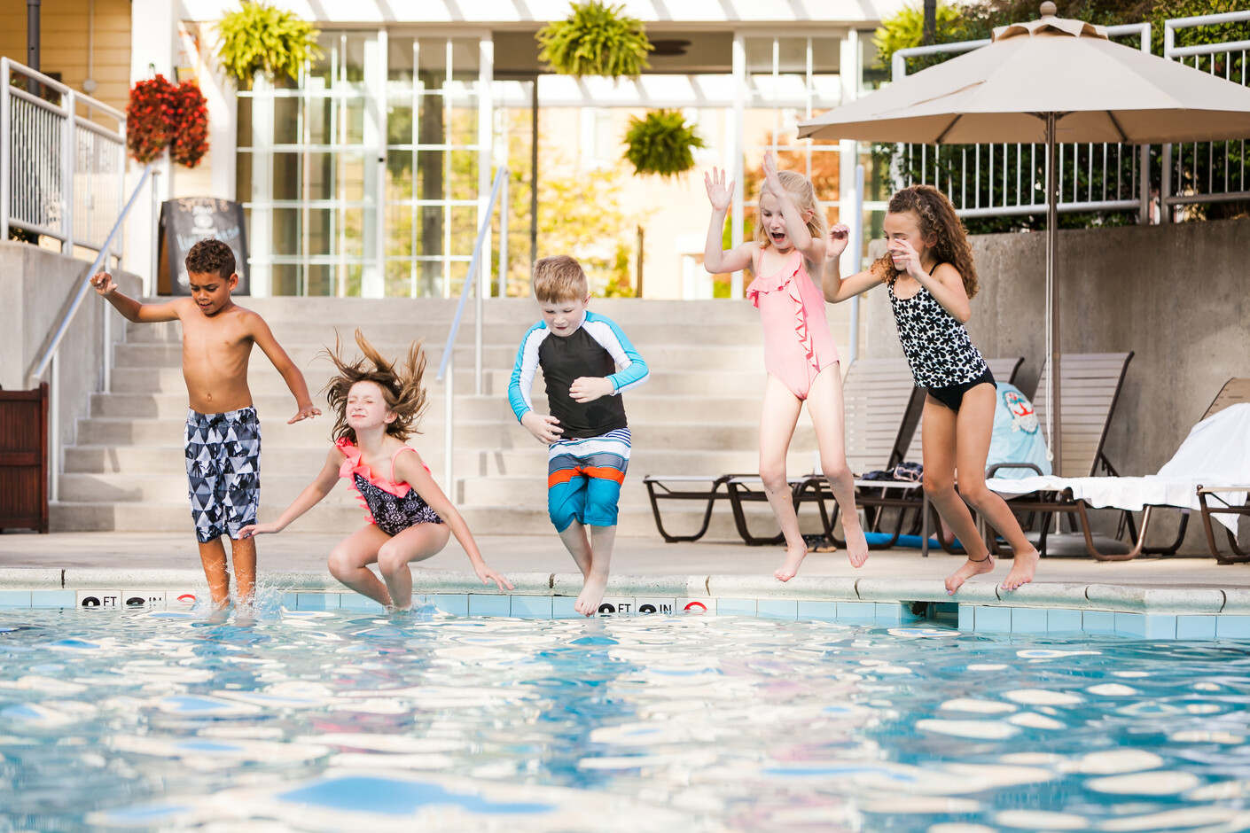 Kids jumping into a pool