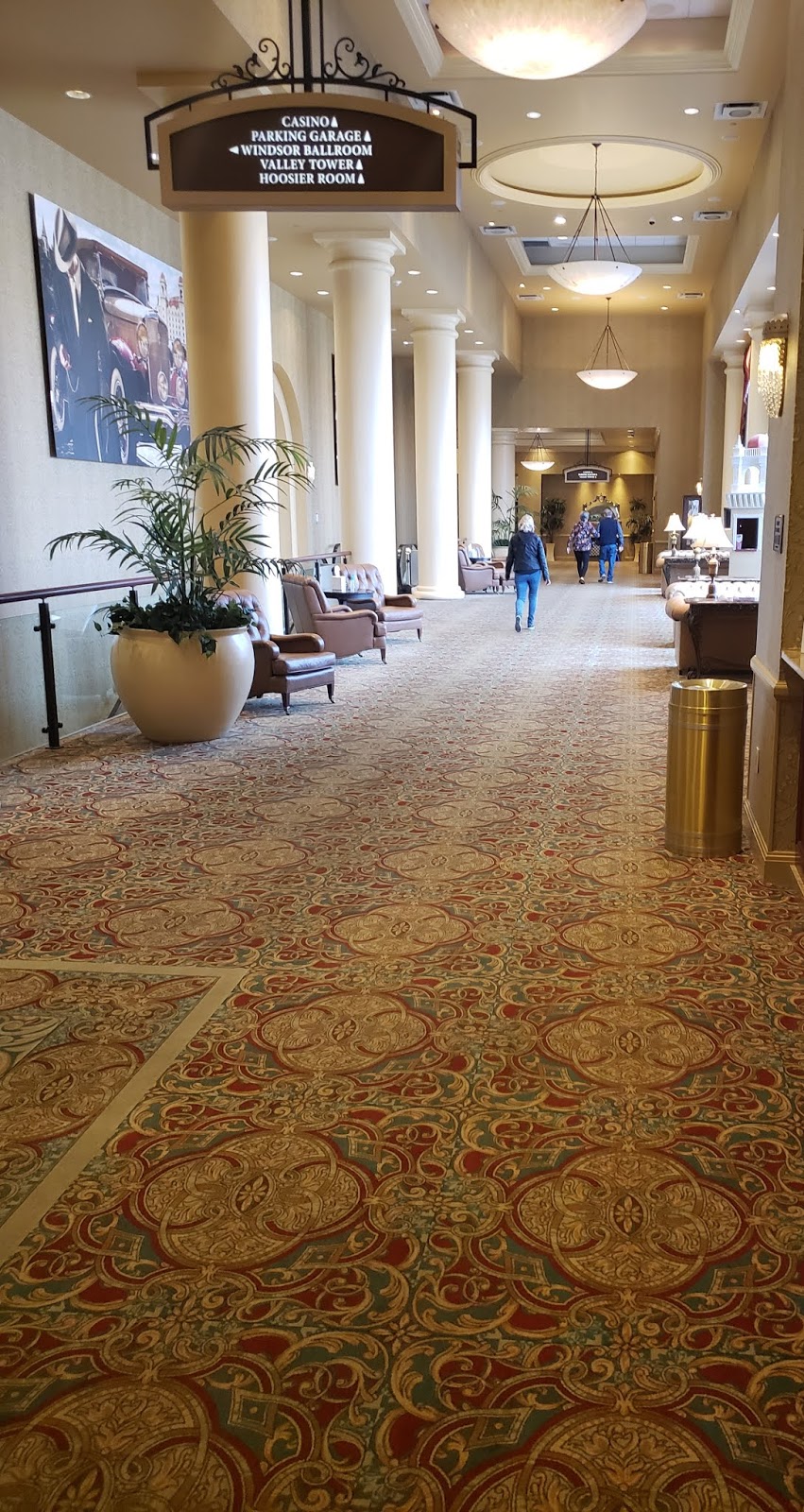 a hallway with columns and people walking