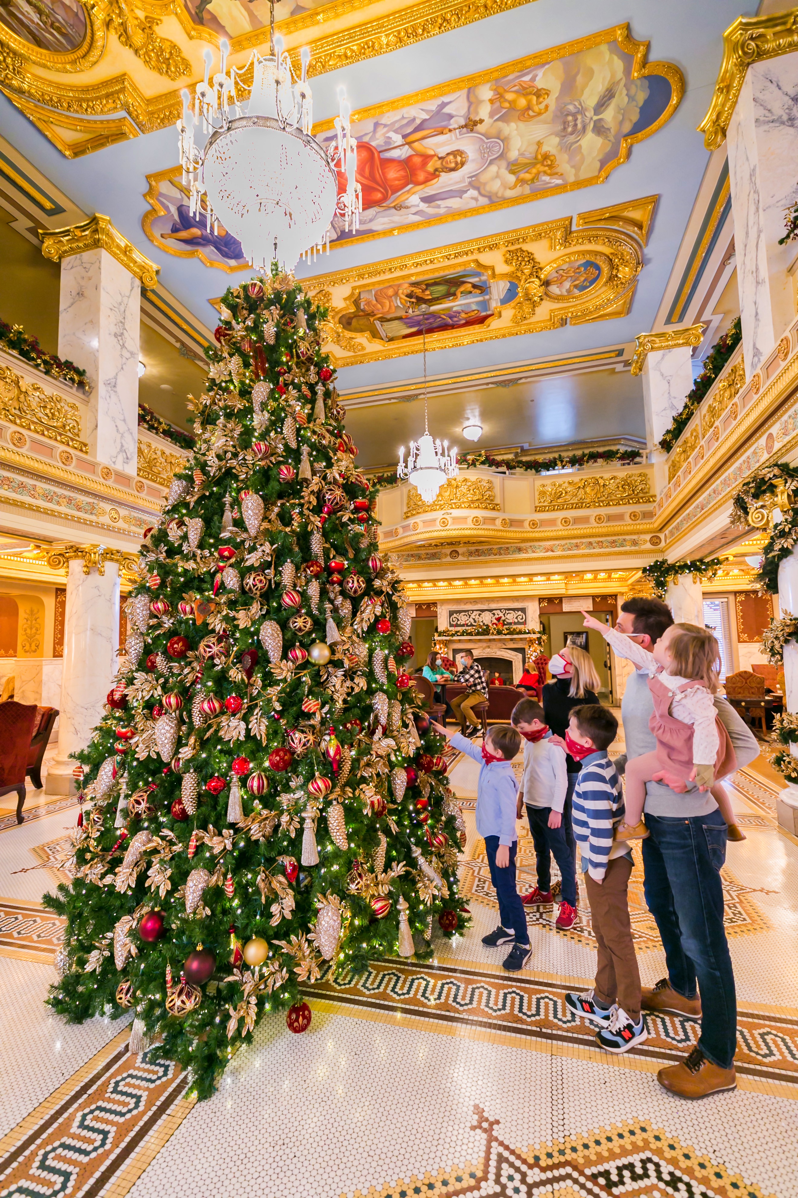 a group of people standing around a christmas tree