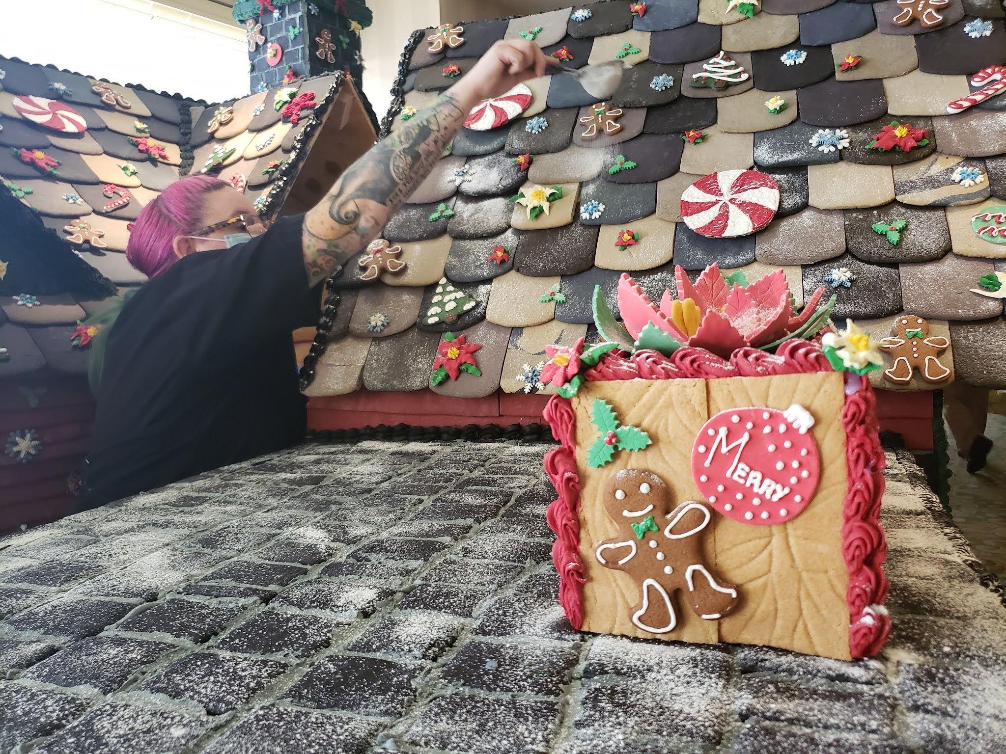 a person painting a gingerbread house