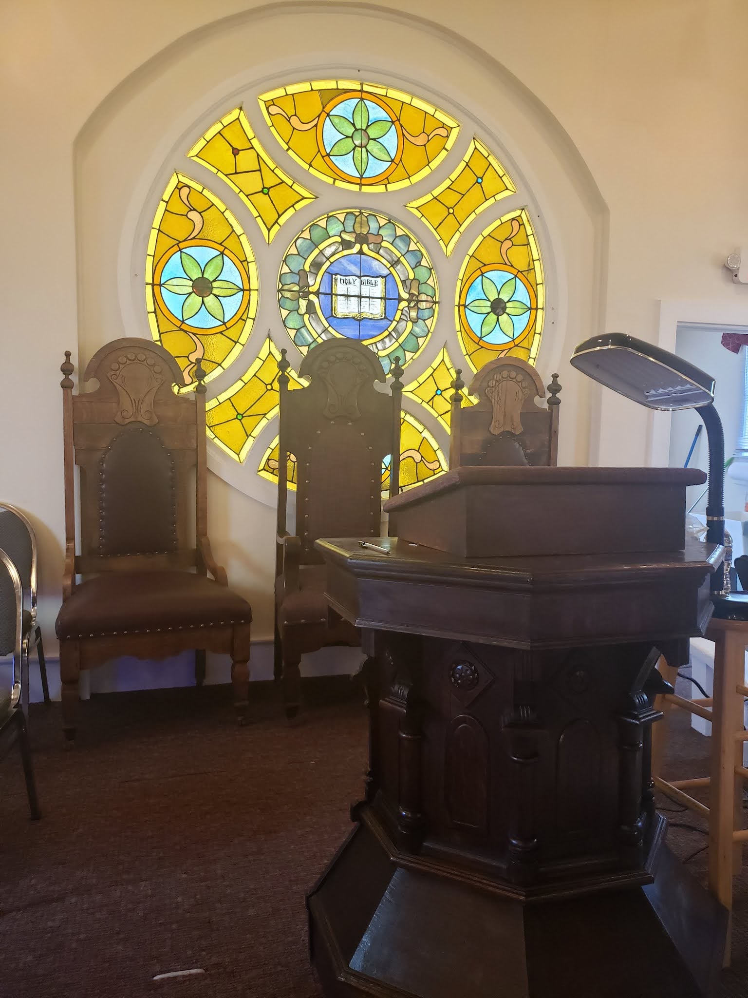 a room with a stained glass window and a podium