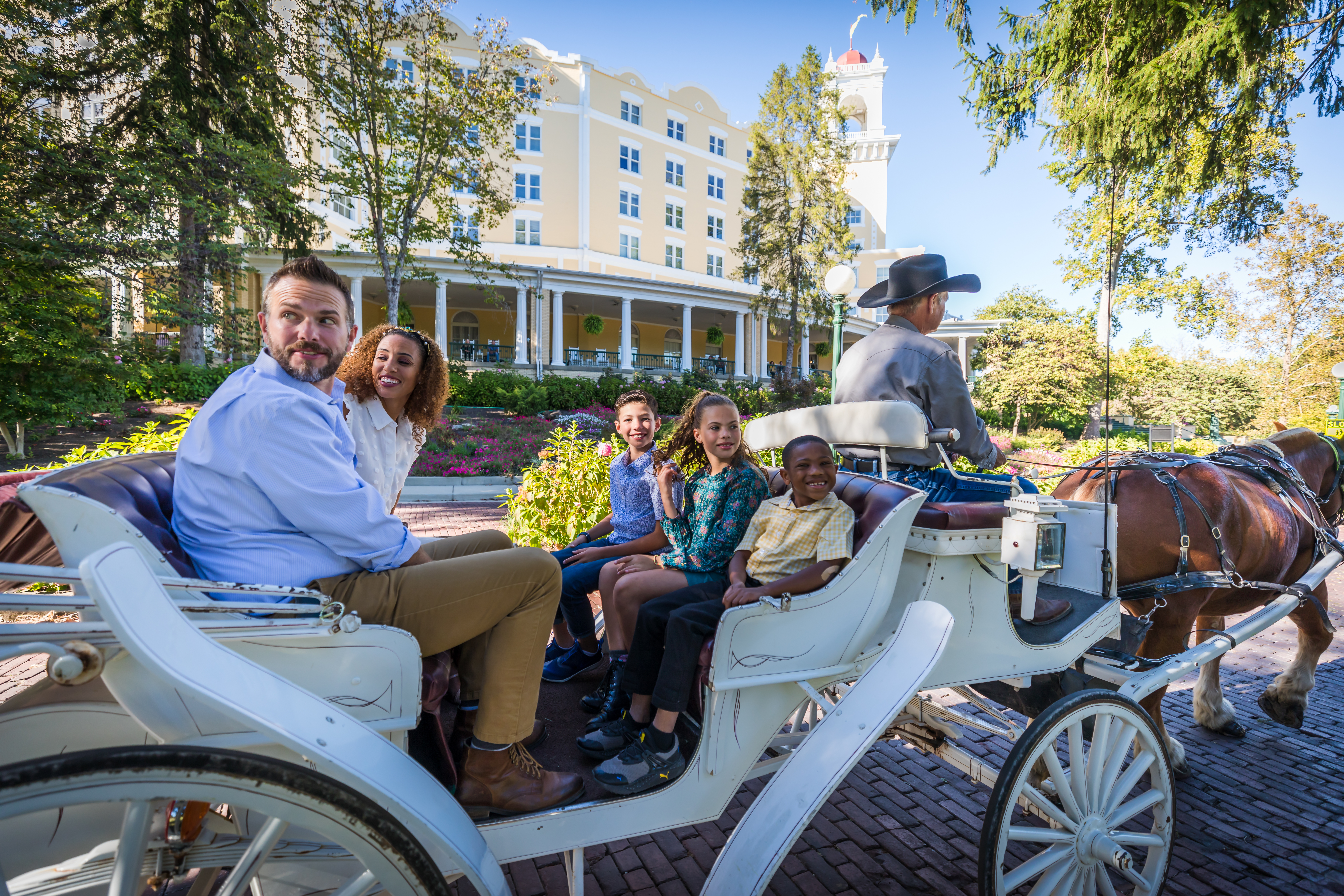 a group of people sitting on a horse carriage