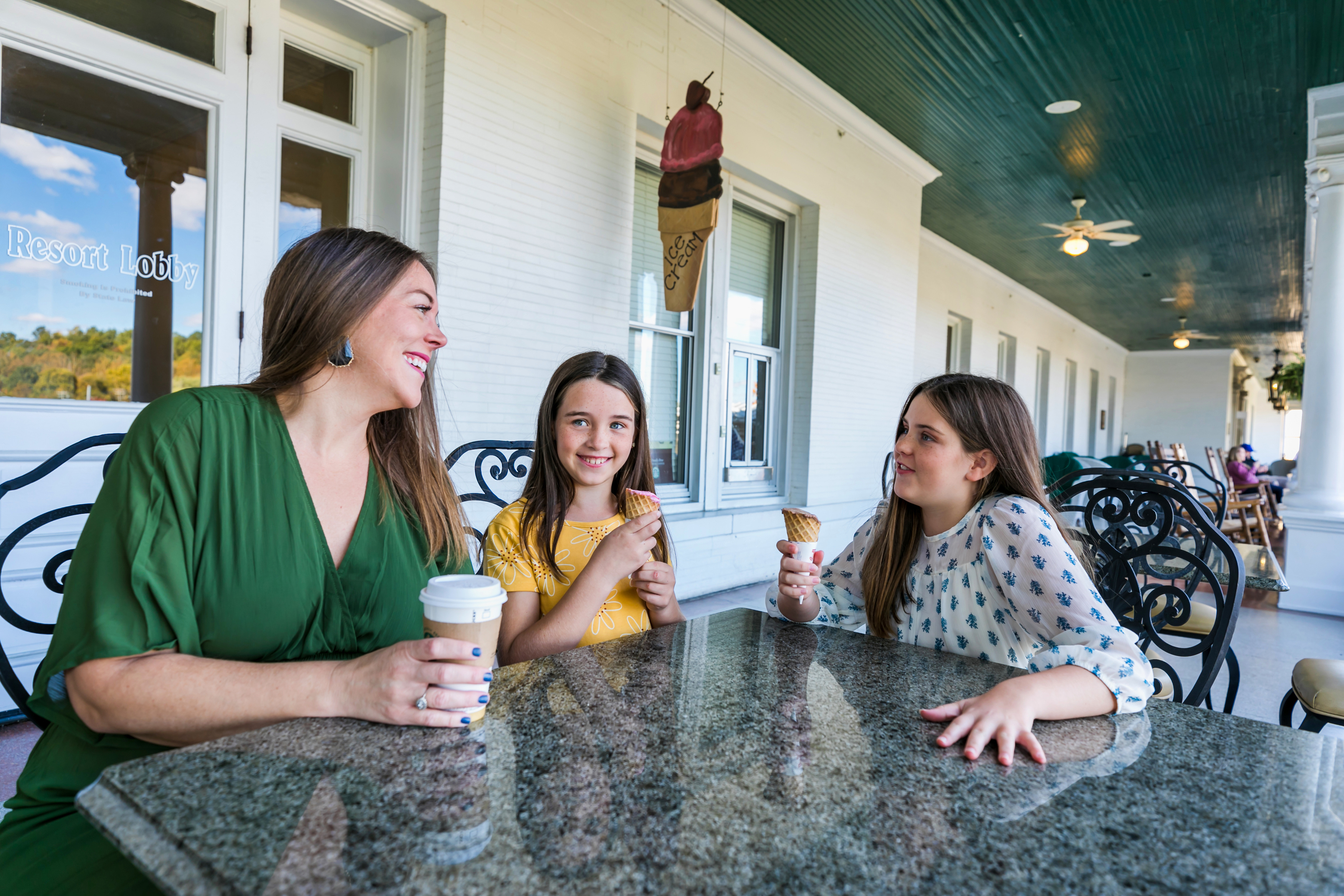 a group of people sitting at a table with ice cream cones