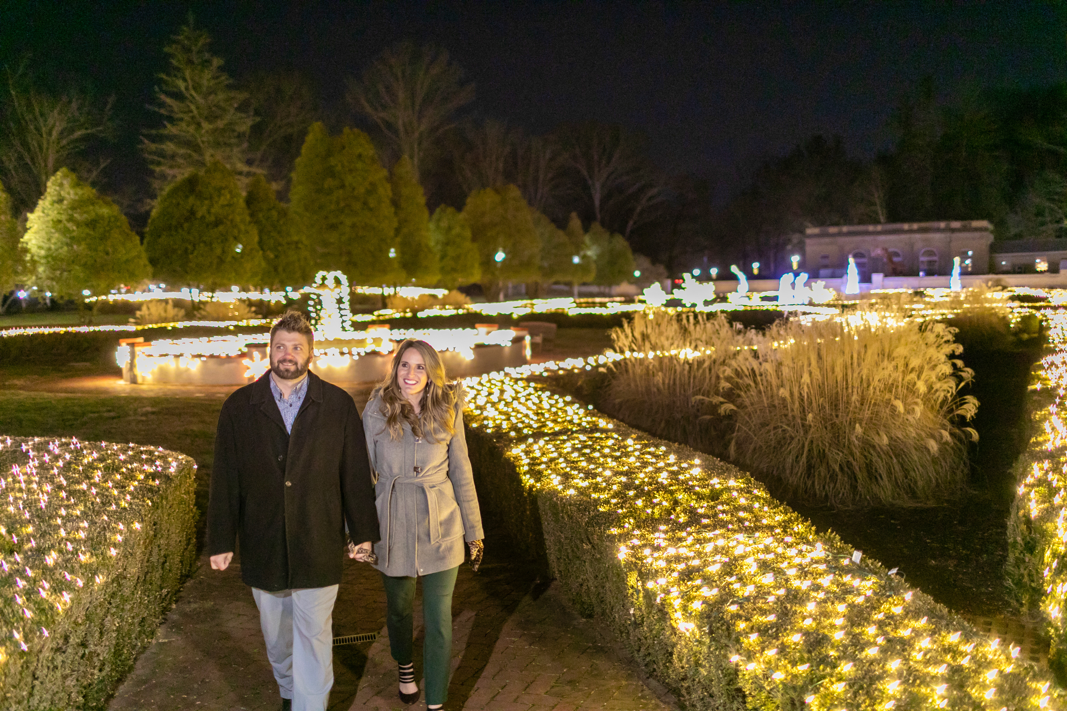 a man and woman holding hands in a garden