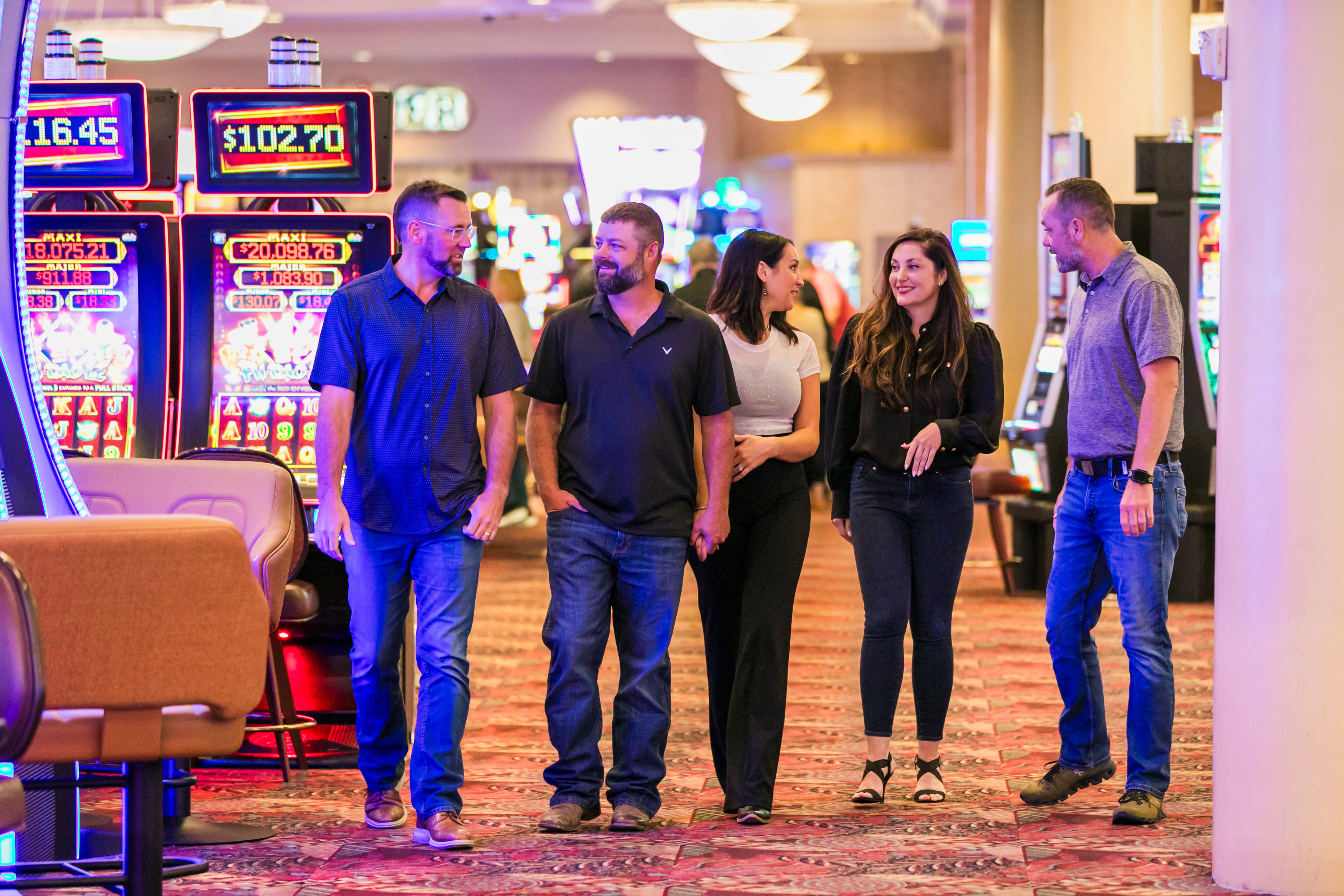 a group of people walking in a casino