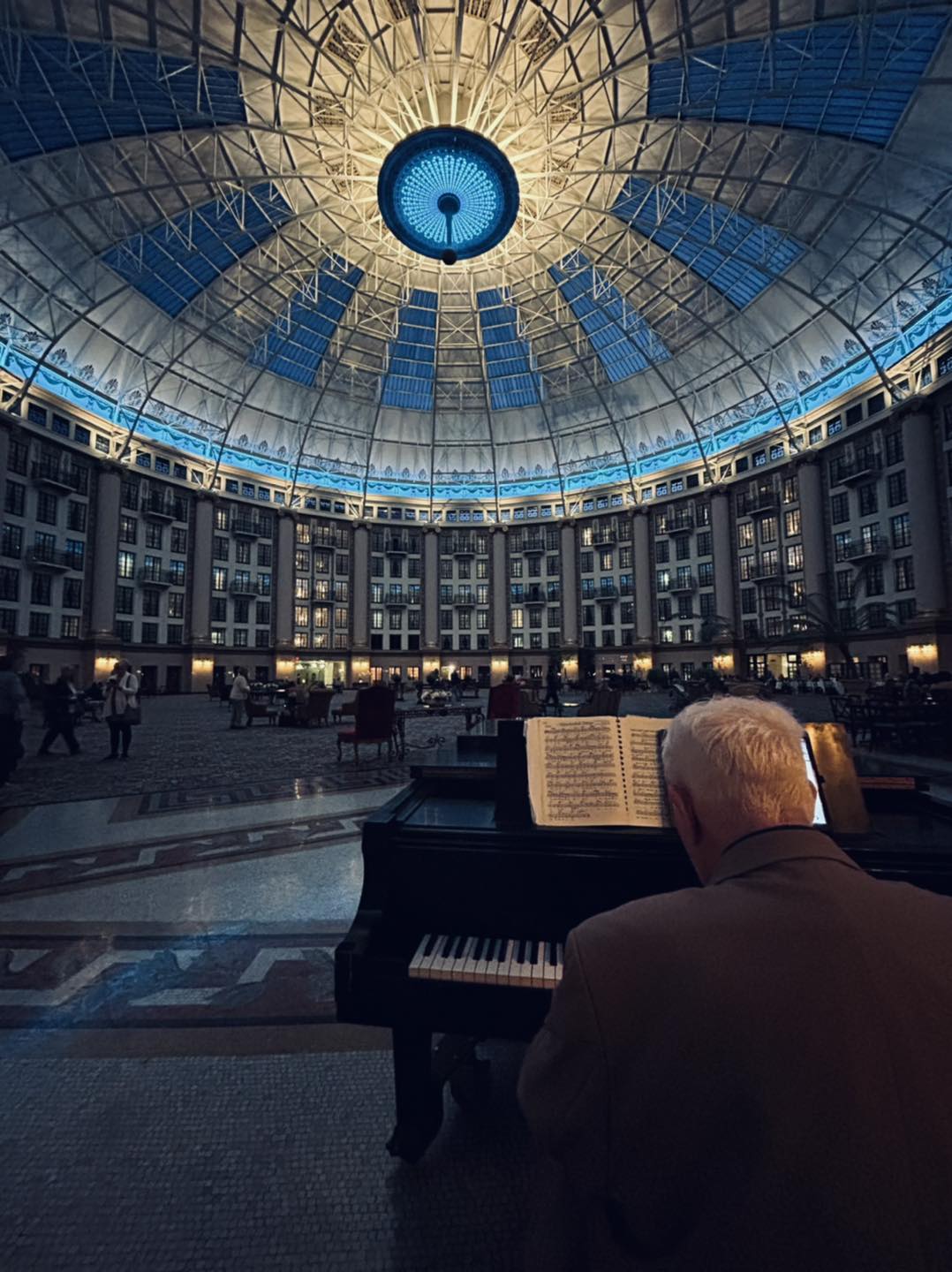 a man playing piano in a large building