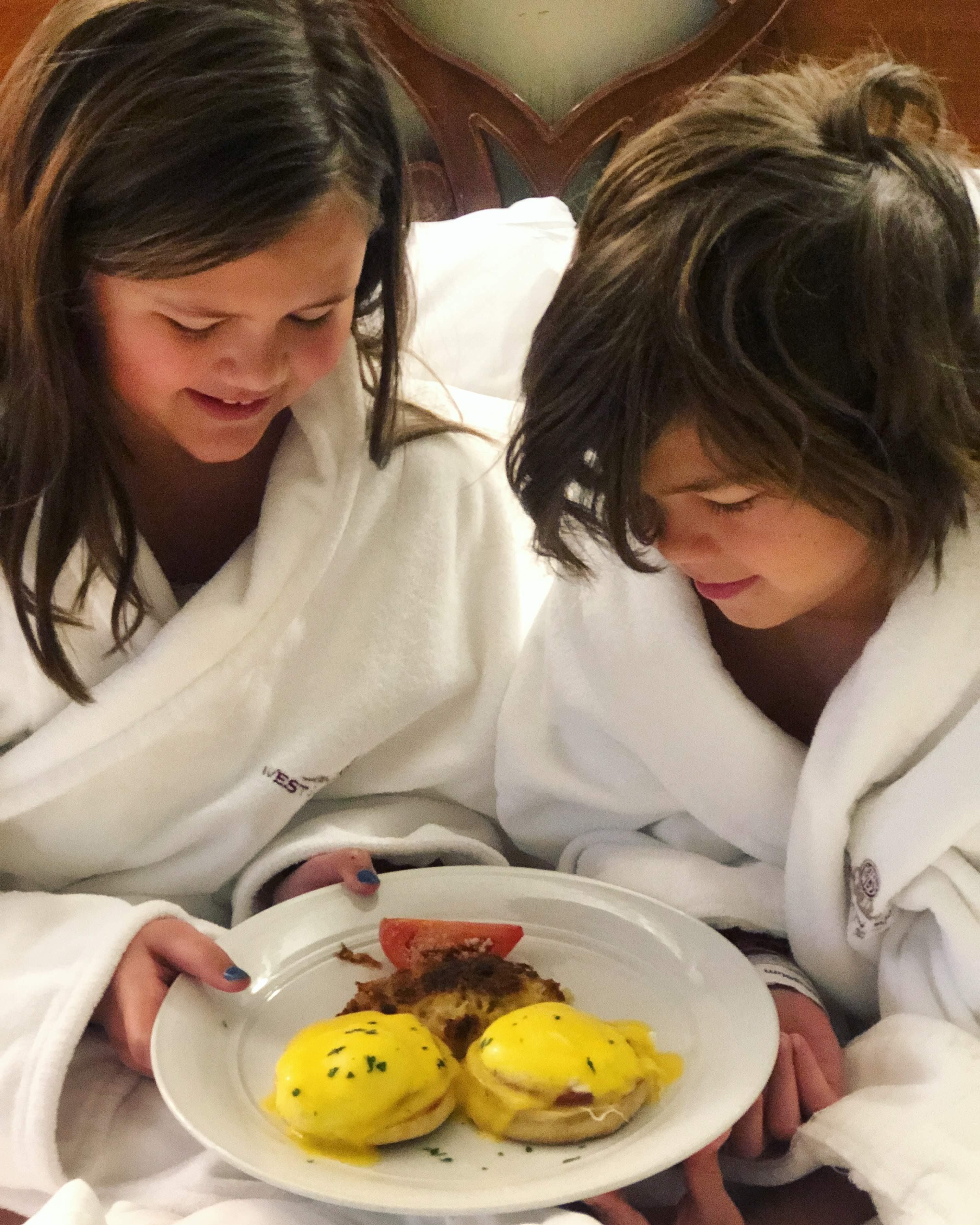 two girls in white robes with food on a plate