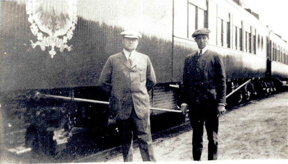 a couple of men standing next to a train