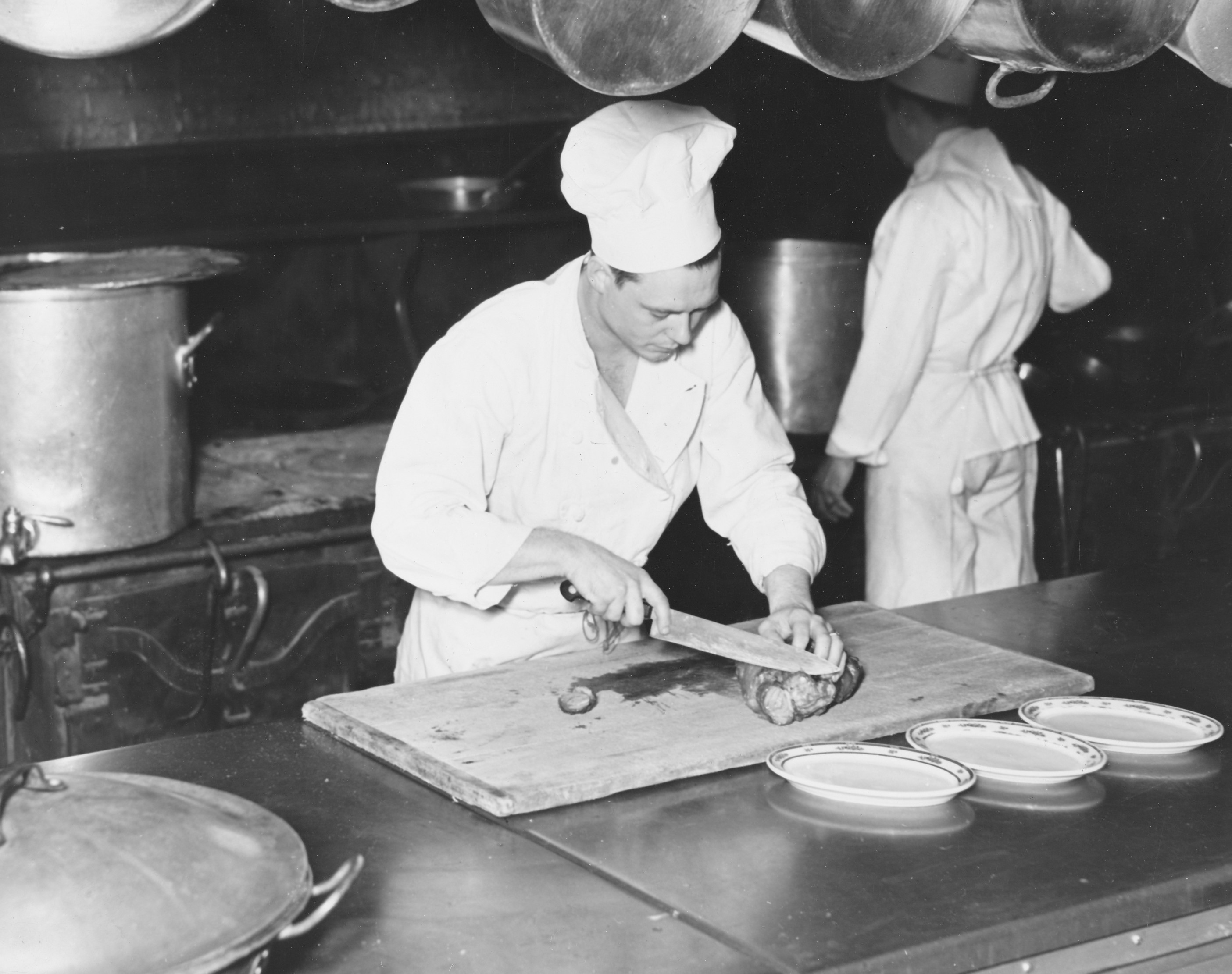 a chef cutting food in a kitchen