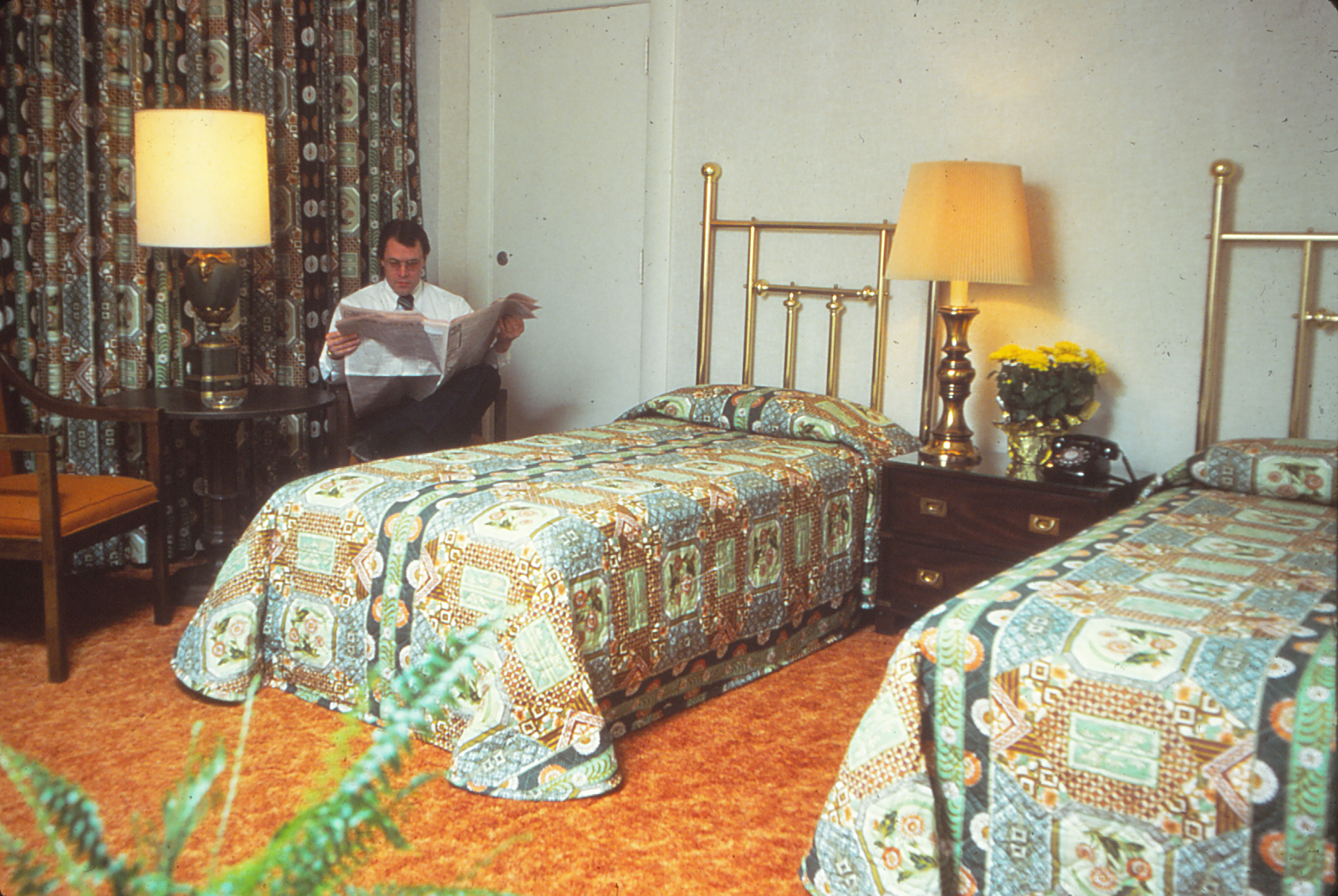 a man sitting in a room with two beds