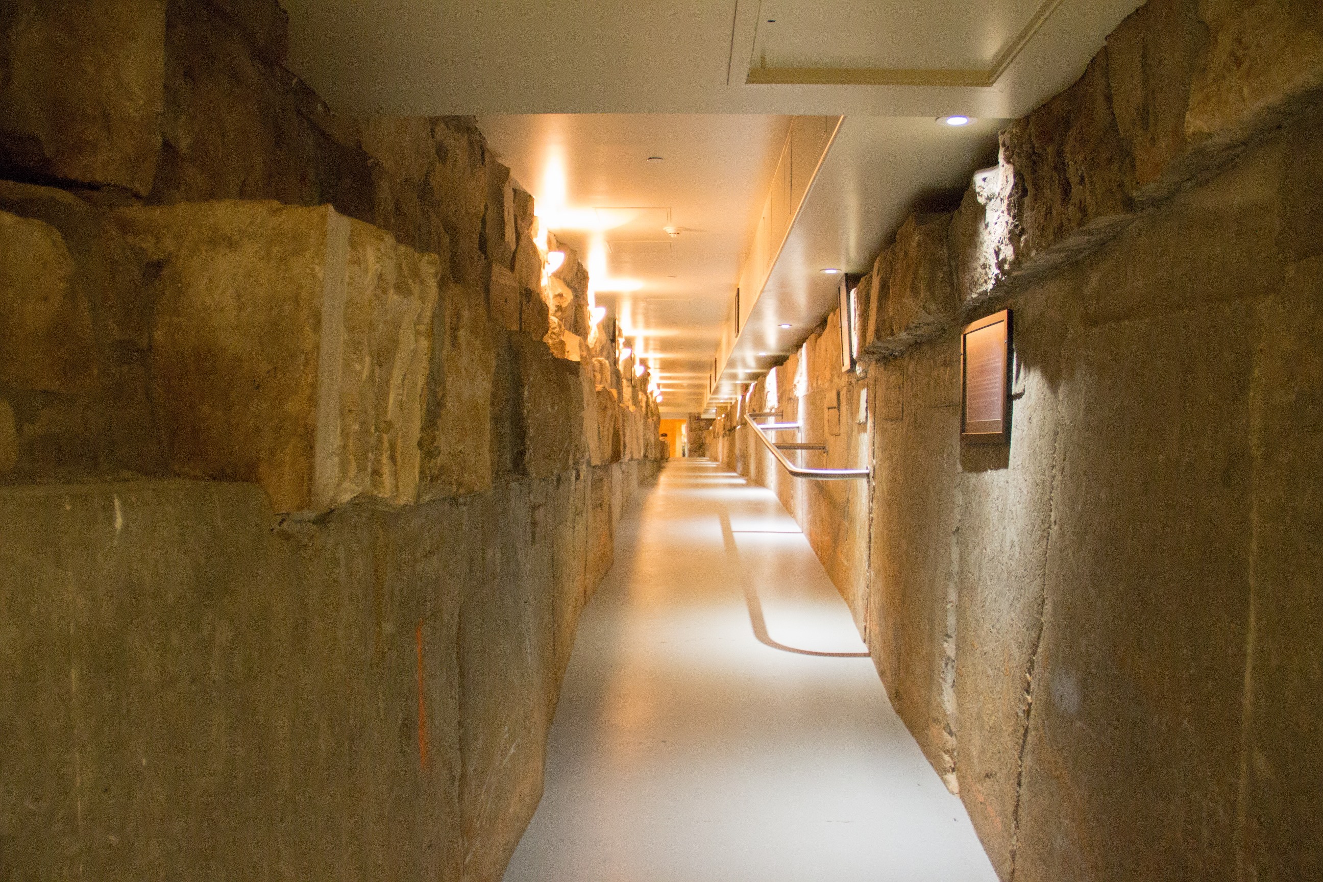 a long hallway with a stone wall