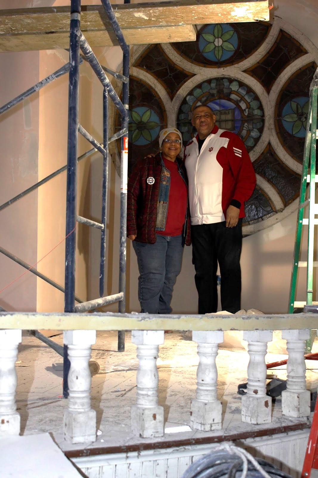 a man and woman standing in front of a stained glass window