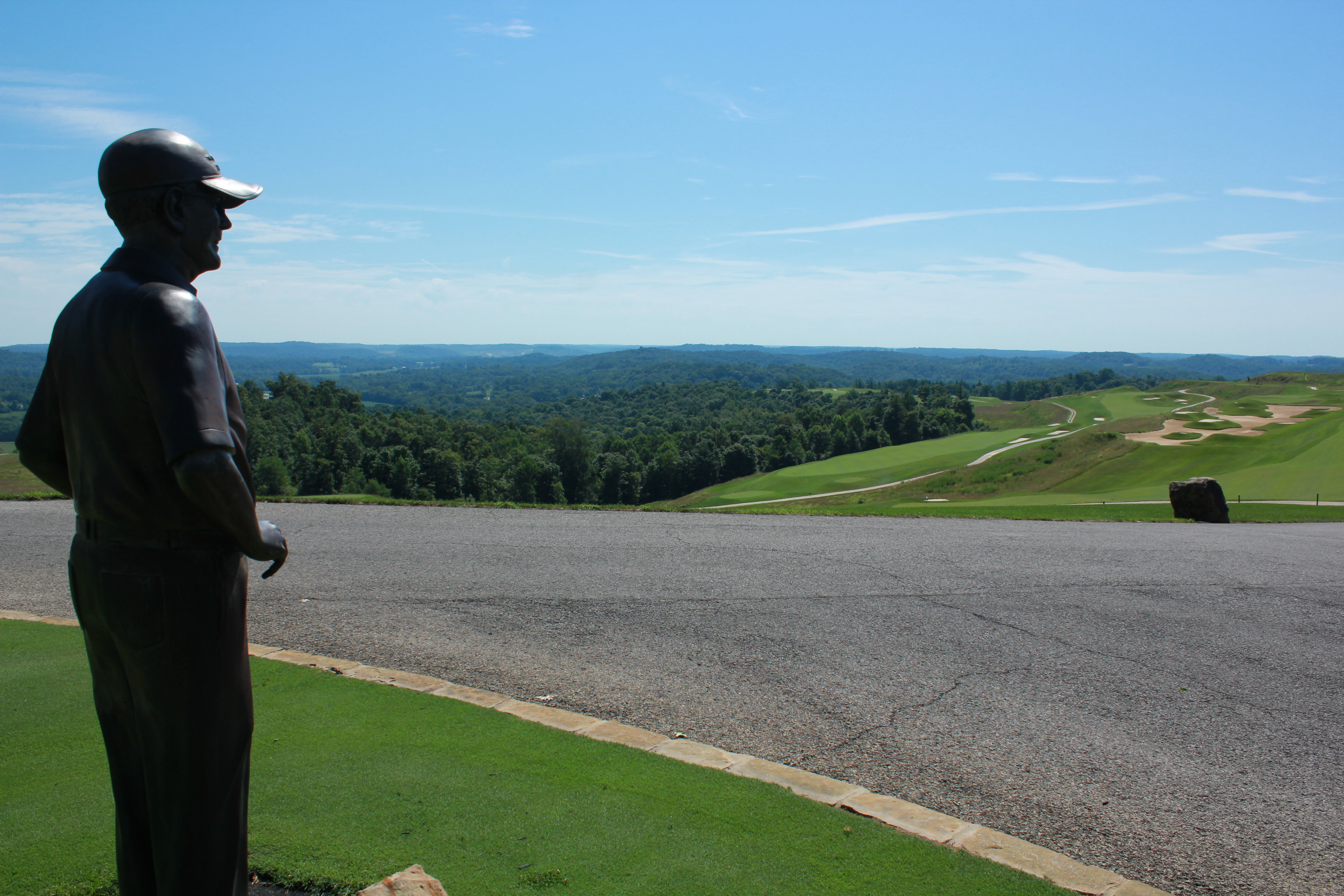 a statue of a man in a hat on a hill