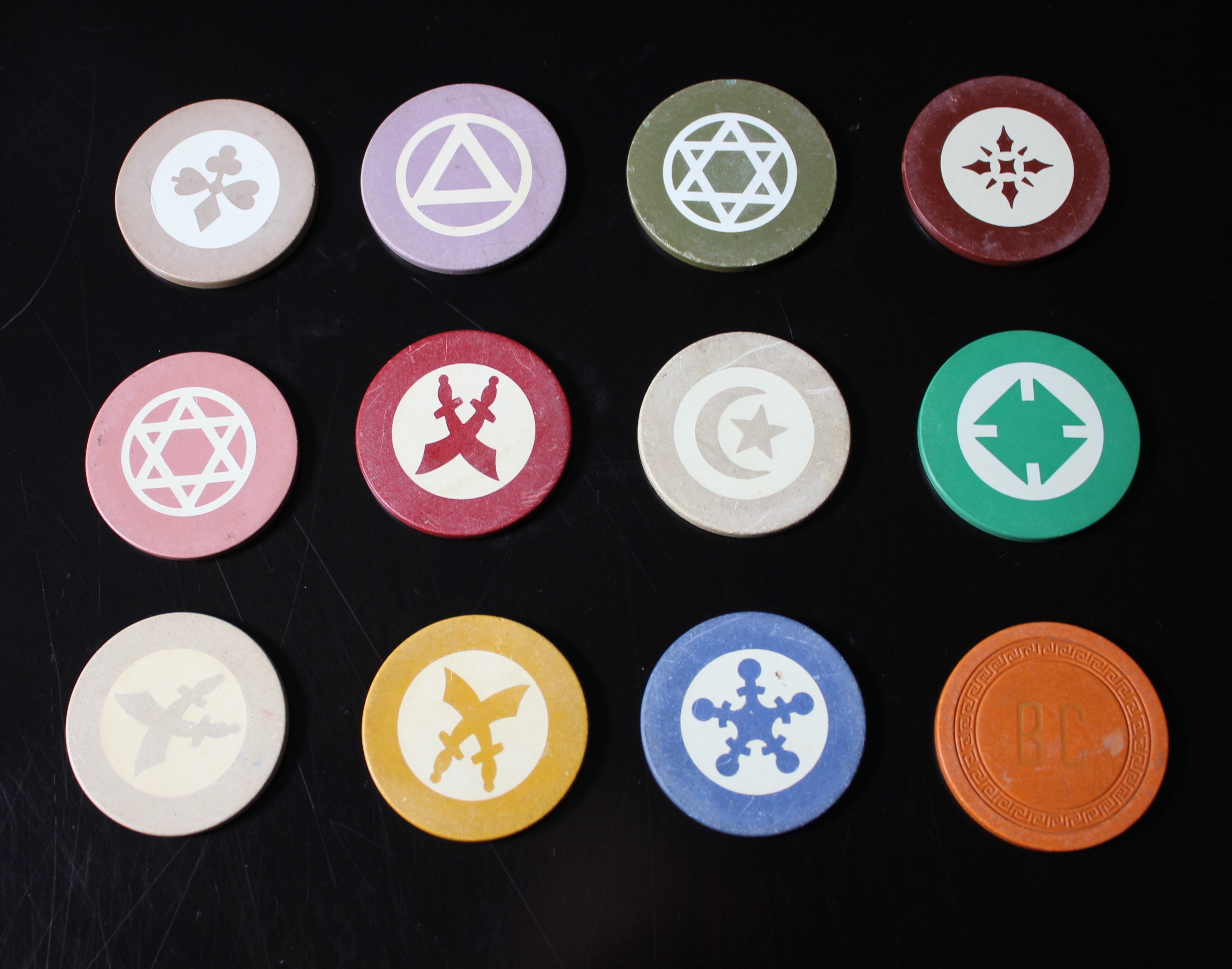 a group of colorful round tokens with symbols on them