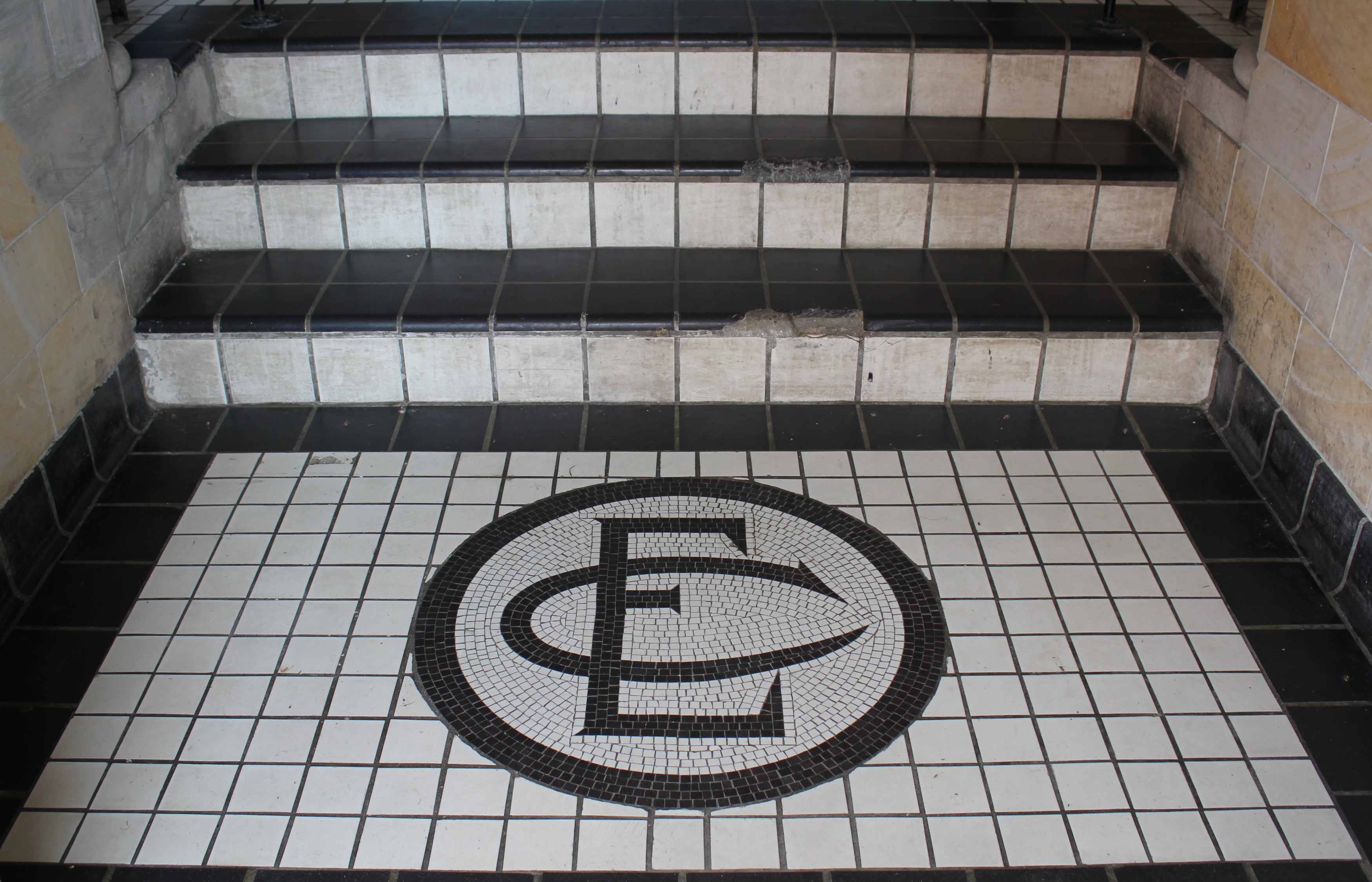 a black and white tiled floor with a letter e on the floor