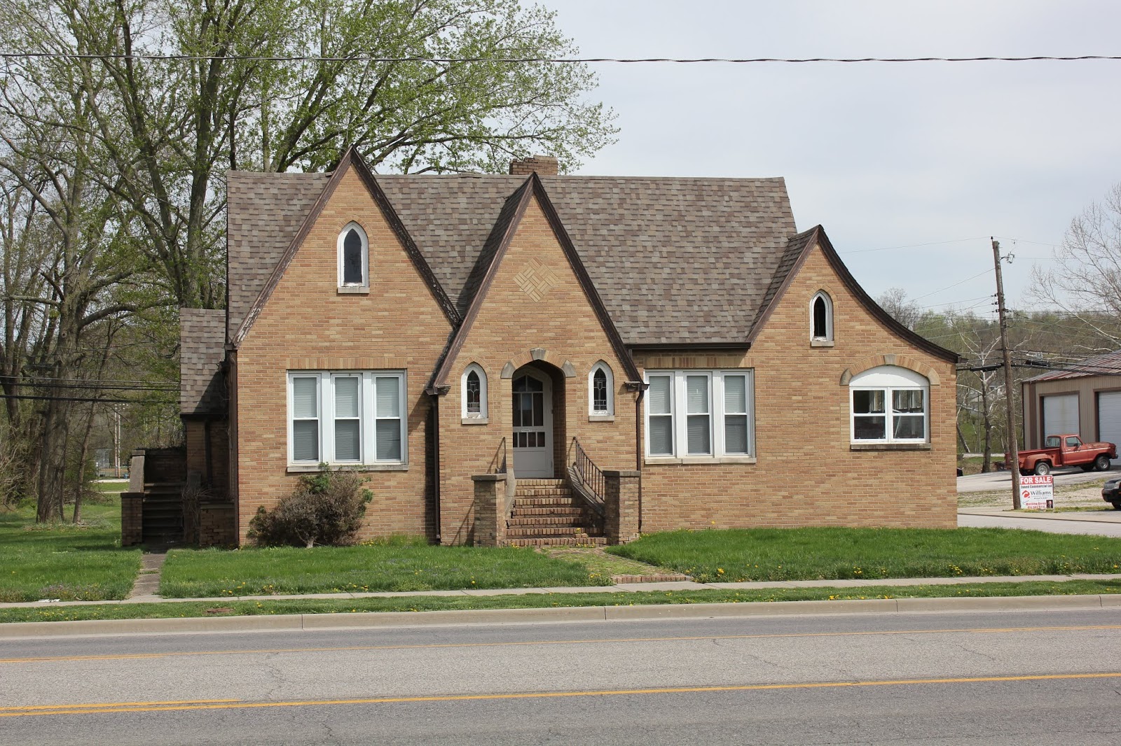 a brick house with a lawn and a tree