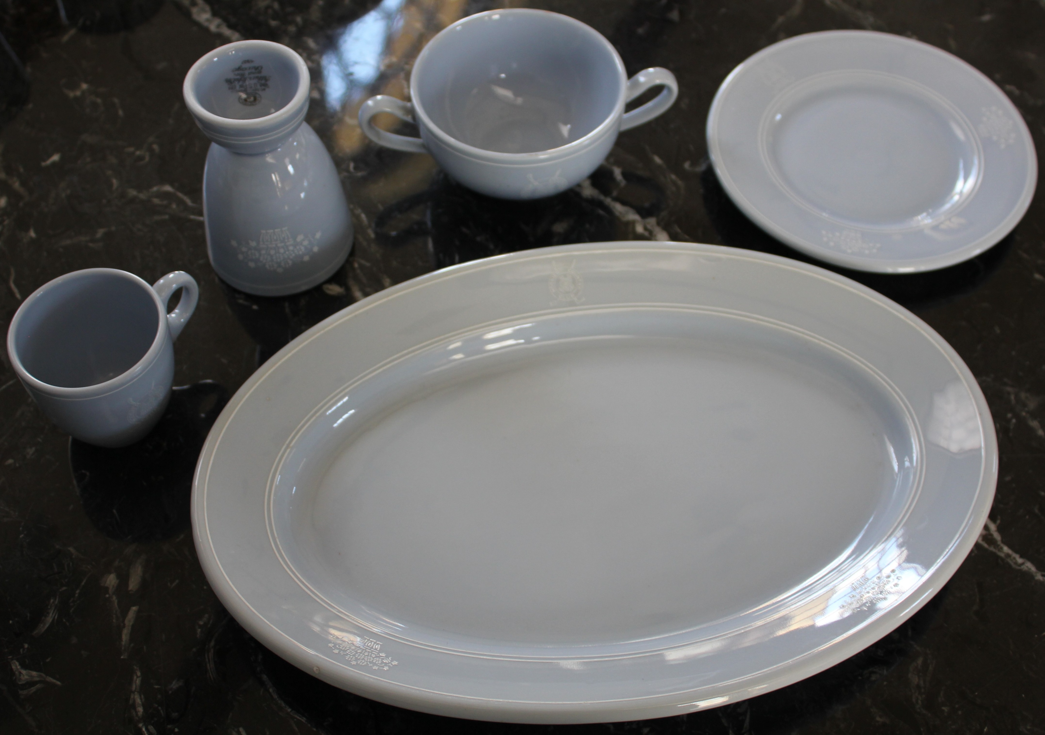 a white plate and cups on a marble table