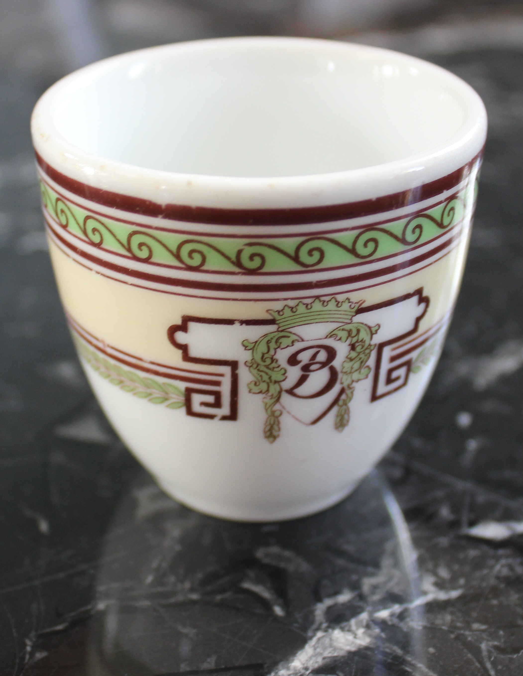 a small white cup with a red and green design