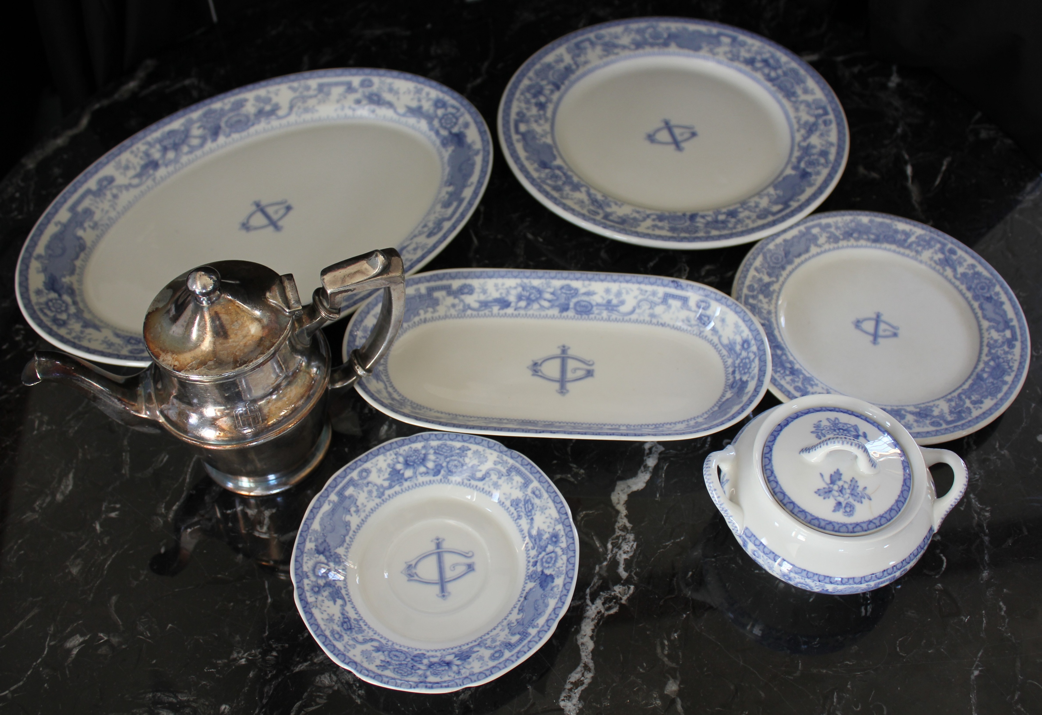 a group of plates and a teapot on a marble surface