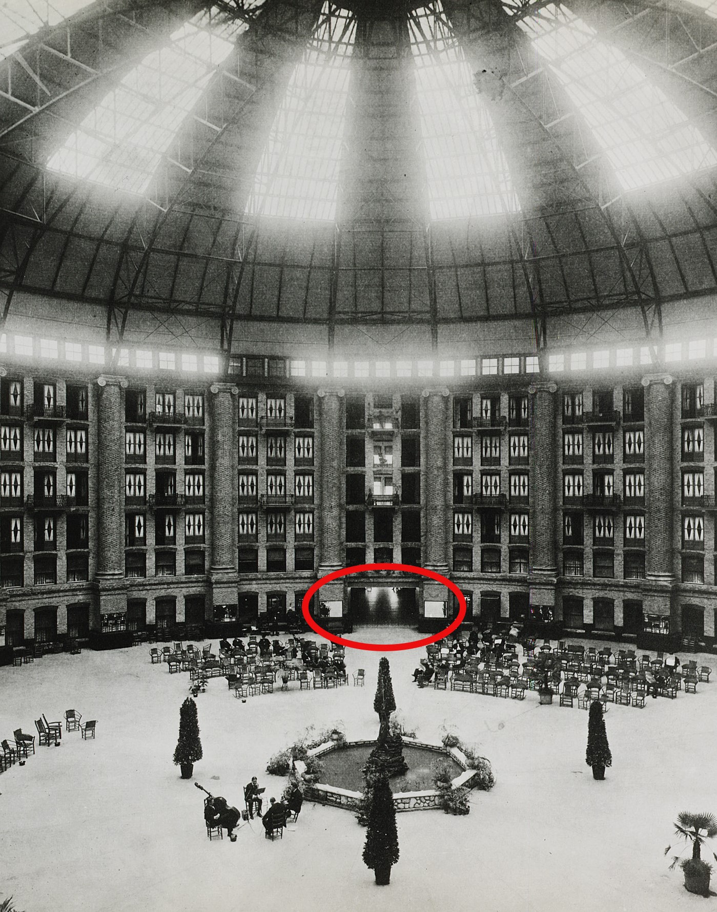 a circular building with a circular fountain and people in it