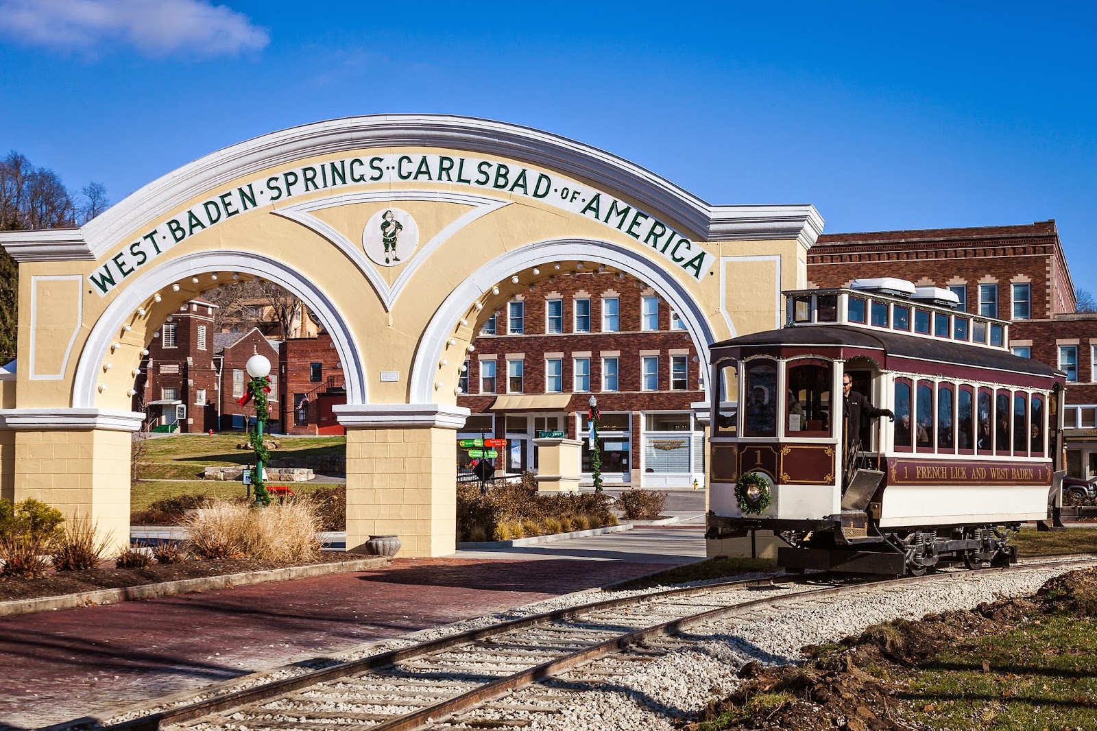 a train on tracks under a archway