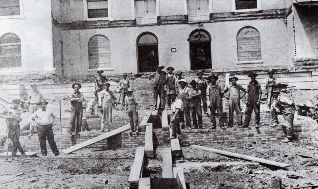 a group of men standing in front of a building