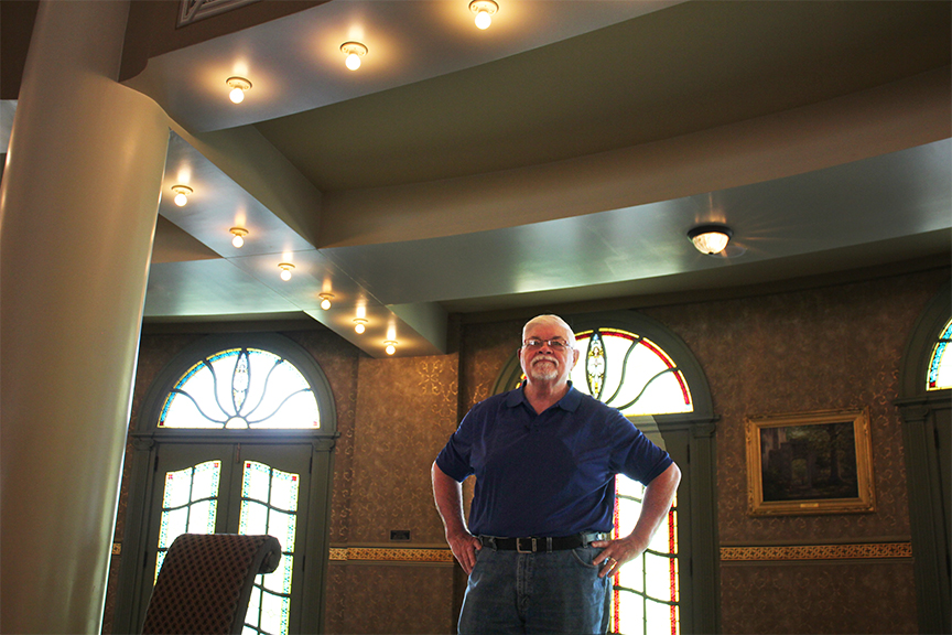 a man standing in a room with a door and windows