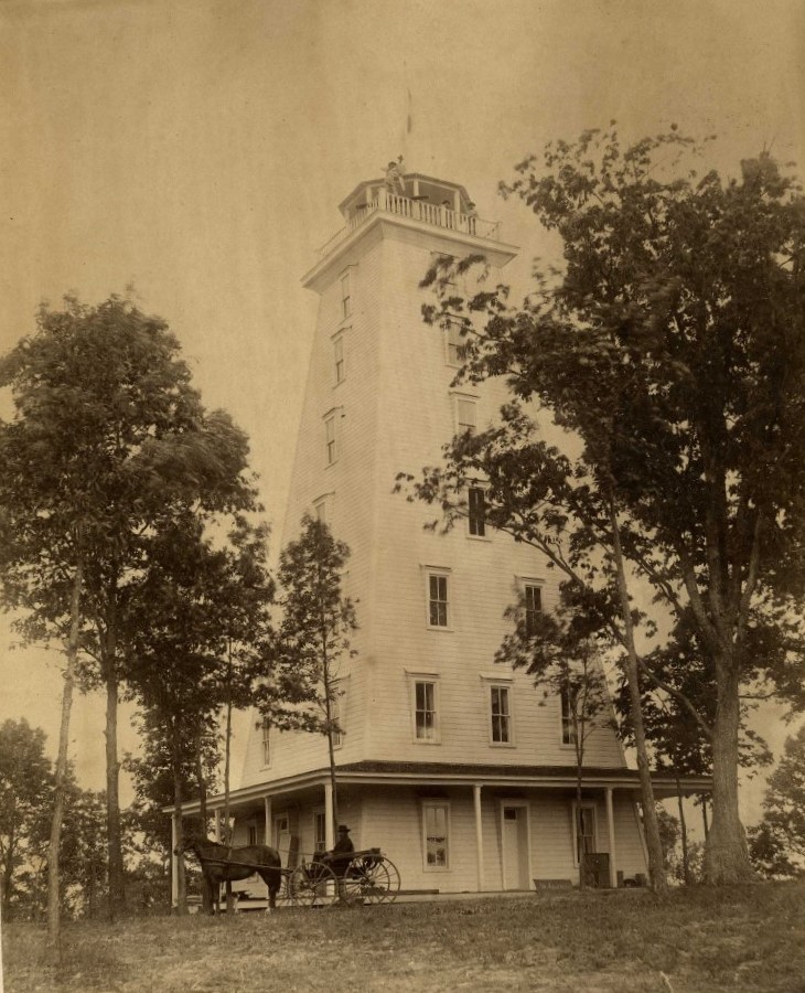 a horse carriage in front of a lighthouse