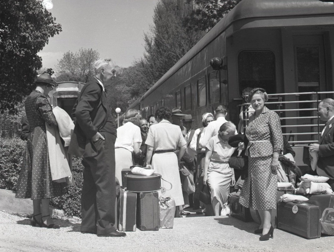 a group of people standing next to a train