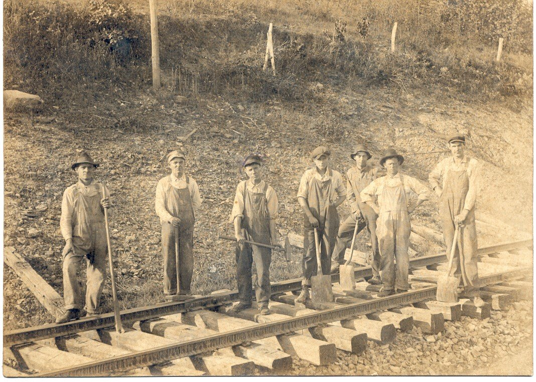 a group of men standing on a railway track